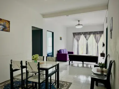 a dining room and living room with a table and chairs at Ammara Homestay Emerald Avenue Cameron Highlands in Brinchang