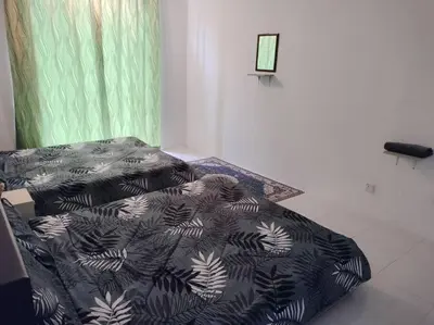 a bed with a black and white comforter in a room at Ammara Homestay Emerald Avenue Cameron Highlands in Brinchang