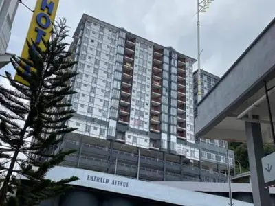 a large hotel building with a tree in front of it at Ammara Homestay Emerald Avenue Cameron Highlands in Brinchang