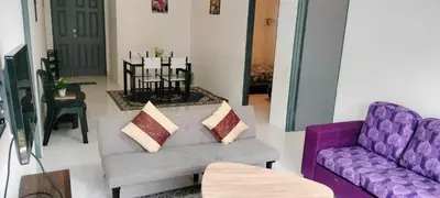 a living room with two purple couches and a table at Ammara Homestay Emerald Avenue Cameron Highlands in Brinchang