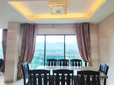 a dining room with a table and chairs and a large window at Ipoh Kinta river front luxury pent house 4br 18pax in Ipoh