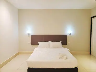 a bedroom with a large bed with white sheets at Ipoh Kinta river front luxury pent house 4br 18pax in Ipoh