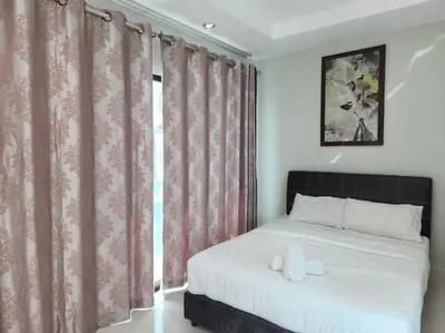 a bedroom with a white bed with pink curtains at Ipoh Kinta river front luxury pent house 4br 18pax in Ipoh