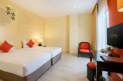 a hotel room with two beds and a television at Hotel 19, Penang in George Town