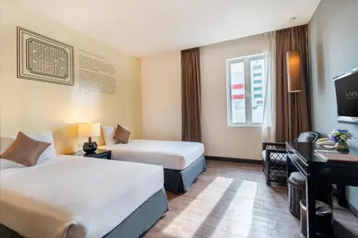 a hotel room with two beds and a television at Hotel 19, Penang in George Town