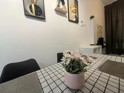 a table with a vase with flowers on it at Ipoh Anderson Suite 1802 By Hopestay in Ipoh