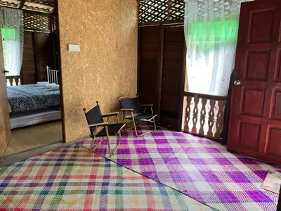 a room with two chairs and a rug on the floor at River Chalet Kemangi Valley Baling in Kampong Kemangi