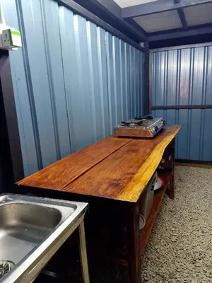 a kitchen with a wooden table and a sink at River Chalet Kemangi Valley Baling in Kampong Kemangi