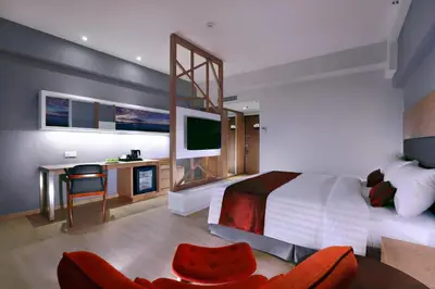 a bedroom with a bed and a desk with a tv at Neo+ Penang in George Town