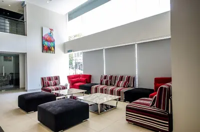 a waiting room with red chairs and a table at Neo+ Penang in George Town
