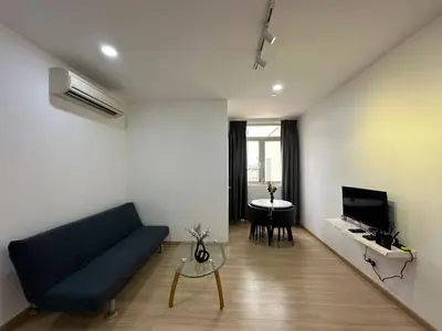 a living room with a blue couch and a table at Netflix Studio Seaview 118Island Plaza in Tanjong Tokong