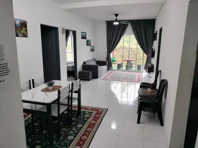 a dining room and living room with a table and chairs at Ammara Homestay 2 Emerald Avenue Brinchang in Brinchang