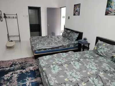 a bedroom with two beds and a mirror at Ammara Homestay 2 Emerald Avenue Brinchang in Brinchang