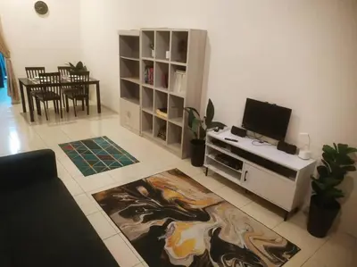 a living room with a television and a living room with a table at Setia Homestay Chemor Setia in Chemor