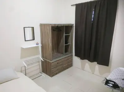 a bedroom with a bed and a dresser with a window at Setia Homestay Chemor Setia in Chemor