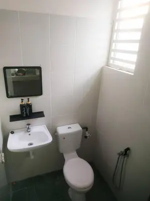 a white bathroom with a toilet and a sink at Setia Homestay Chemor Setia in Chemor