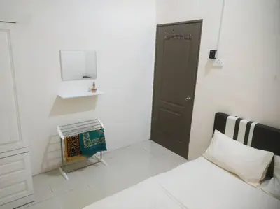a small white room with a bed and a door at Setia Homestay Chemor Setia in Chemor