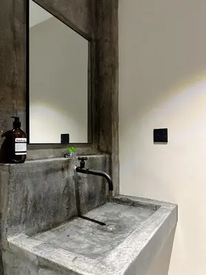 a sink with a mirror and a bottle of soap at The Jubilee Guest House in Ipoh