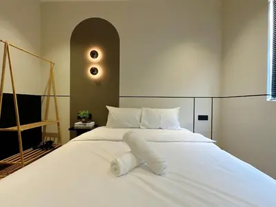 a bedroom with a white bed with white sheets at The Jubilee Guest House in Ipoh