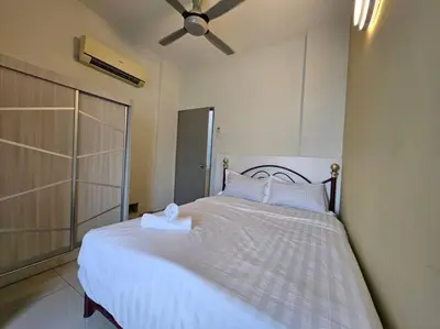 a bedroom with a white bed with a fan at Cozy Nest - Sky Garden Residence Ipoh in Chemor