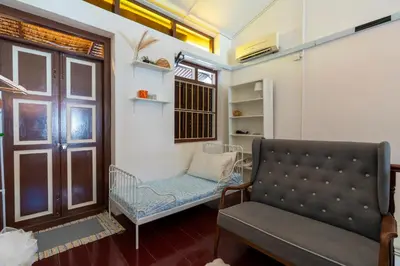 a room with a couch and a chair and a window at The Bibik at 8 Clarke -NEW Entire #Unesco #HeritageHome in George Town