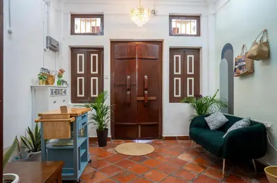a living room with a green couch and a wooden door at The Bibik at 8 Clarke -NEW Entire #Unesco #HeritageHome in George Town