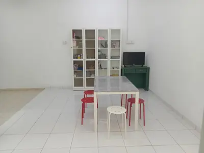 a kitchen with a table and four red stools at Islam Taqwa Homestay in Kuala Lipis