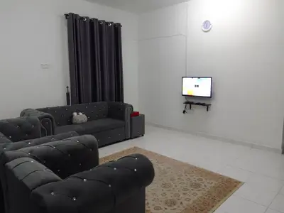 a living room with a couch and a tv at Islam Taqwa Homestay in Kuala Lipis