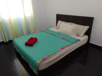 a bed with a red pillow on top of it at Islam Taqwa Homestay in Kuala Lipis