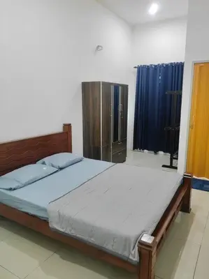 a bedroom with a bed and a blue curtain at Mysa at Tambun Ipoh in Kampong Batu Lapan