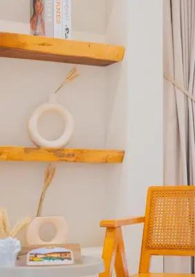 a wooden shelf on a wall with a table and a chair at Ipoh Tiga Pool Villa by Papahost in Ipoh