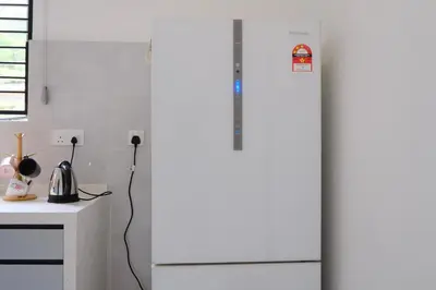 a white refrigerator in a kitchen next to a counter at Homestay Bukit Mertajam - DHome in Bukit Mertajam