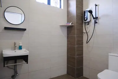 a bathroom with a shower with a sink and a mirror at Homestay Bukit Mertajam - DHome in Bukit Mertajam