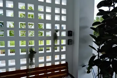 a bench in front of a white wall with a window at Homestay Bukit Mertajam - DHome in Bukit Mertajam
