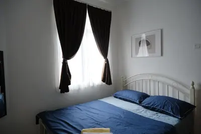 a bedroom with a bed with blue sheets and a window at Homestay Bukit Mertajam - DHome in Bukit Mertajam