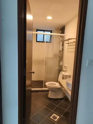 a bathroom with a toilet and a glass shower at Marina Heights Apartment in Lumut