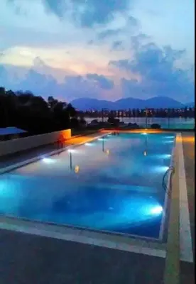 a swimming pool with blue lights on top of a building at Marina Heights Apartment in Lumut