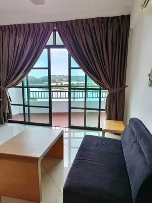 a living room with a couch and a large window at Marina Heights Apartment in Lumut