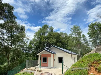 a small white and pink house with trees in the background at Rumah Bukit Jalan Kolam Air in Kuala Kubu Baharu