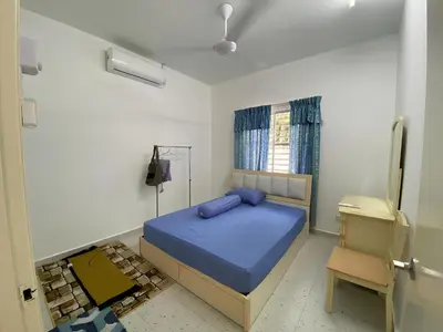 a bedroom with a blue bed and a chair at Rumah Bukit Jalan Kolam Air in Kuala Kubu Baharu