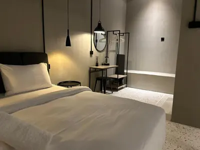 a bedroom with a white bed and a table at M2 Living Townhouse in Ipoh in Ipoh