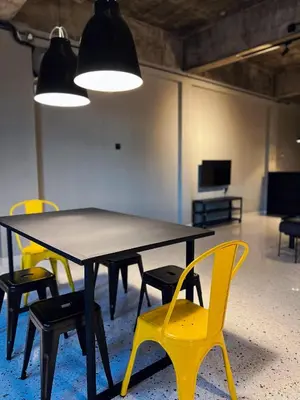 a table with yellow chairs in a room at M2 Living Townhouse in Ipoh in Ipoh