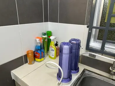 a kitchen counter with cleaning products and a sink at AYAAN HOMESTAY HiLL ViEW IIN FREE WIFI & NETFLIX in Tanah Rata