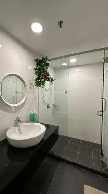 a bathroom with a sink and a glass shower at Seaview Seafront Duplex in Town with WiFi & Full Kitchen 66 in Georgetown