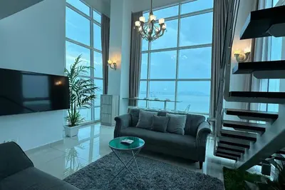 a living room with a couch and a tv at Seaview Seafront Duplex in Town with WiFi & Full Kitchen 66 in Georgetown