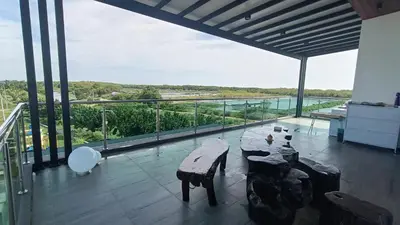 a room with a table and benches on a balcony at Serenity Haven in Sungai Besar