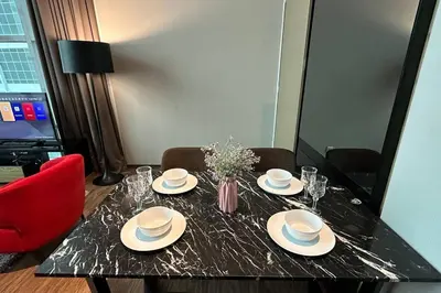 a black table with plates and glasses and a red chair at Seaview Seafront Duplex in Town with WiFi & Full Kitchen 83A in Georgetown