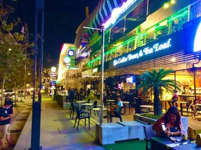a woman sitting in front of a restaurant at night at Seaview Seafront Duplex in Town with WiFi & Full Kitchen 83A in Georgetown