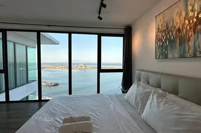 a bedroom with a bed with a view of the ocean at Seaview Premium Duplex in Gurney with WiFi & Full Kitchen 12B in George Town