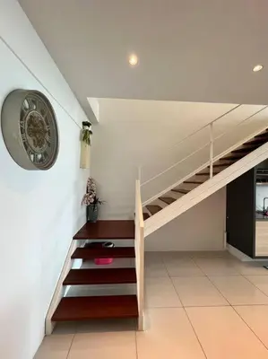 a staircase in a house with a clock on the wall at Seaview Premium Duplex in Gurney with WiFi & Full Kitchen 12B in George Town